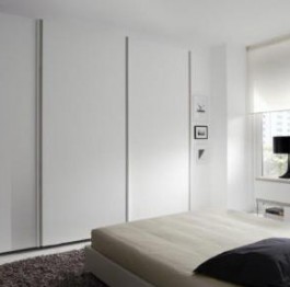 Una solución muy practica es colocar el armario de puertas correderas al fondo de la cama